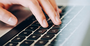 woman typing on laptop keyboard