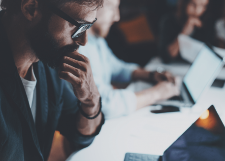 group of businessmen working over laptop