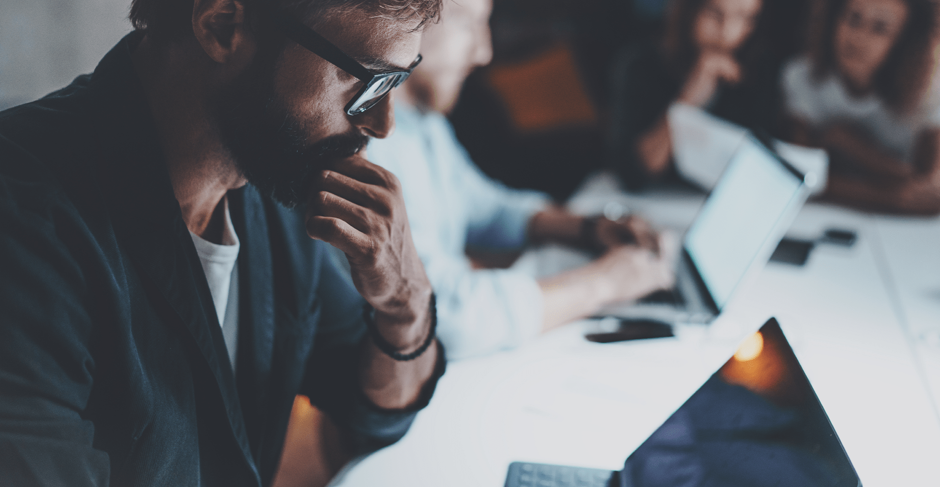 group of businessmen working over laptop