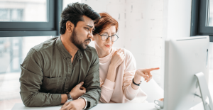 group of business colleagues dealing with malfunctioning computer