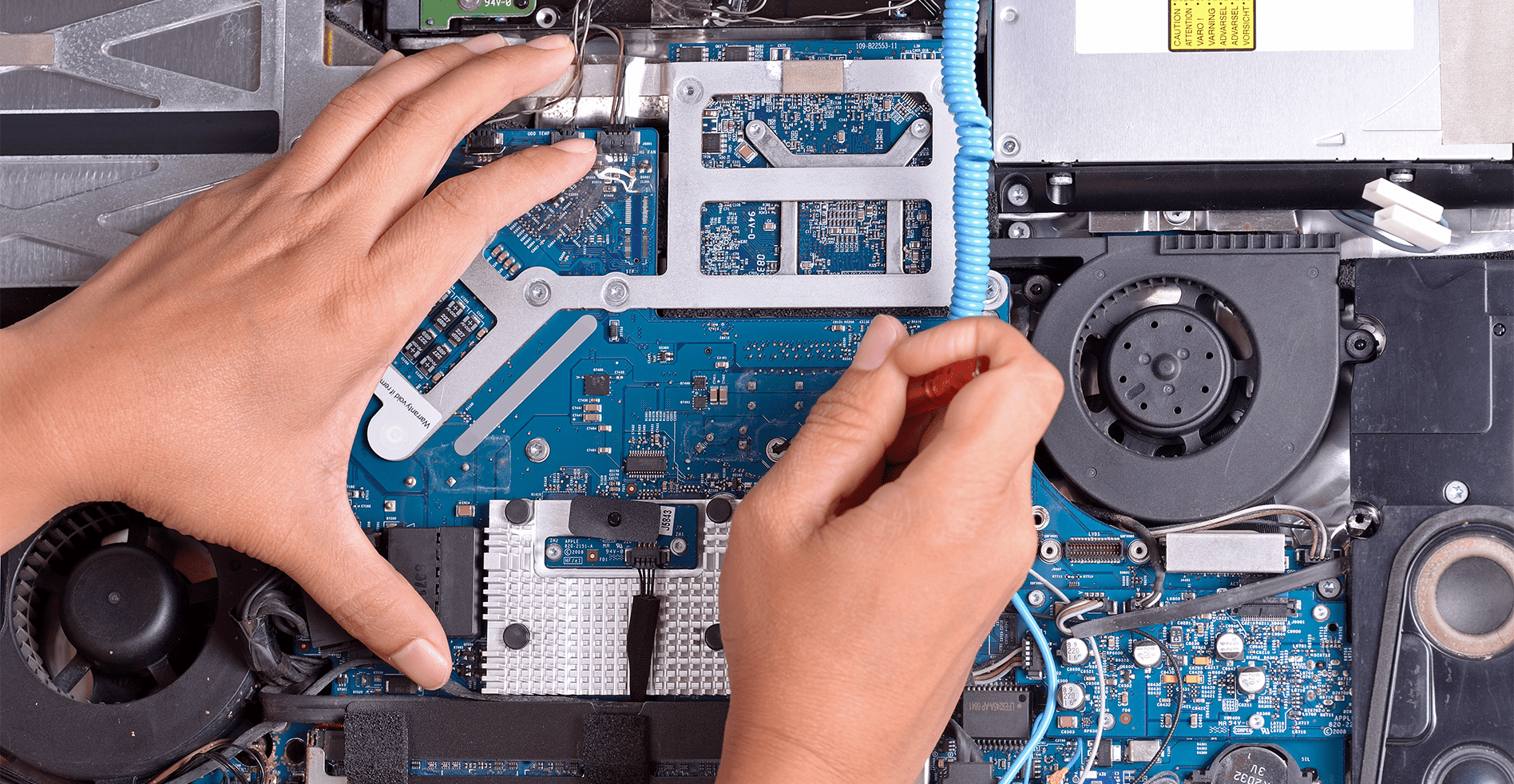 technician repairing macbook motherboard