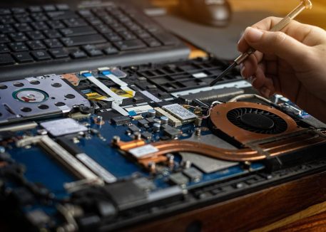 Person using tool to fix inside of computer