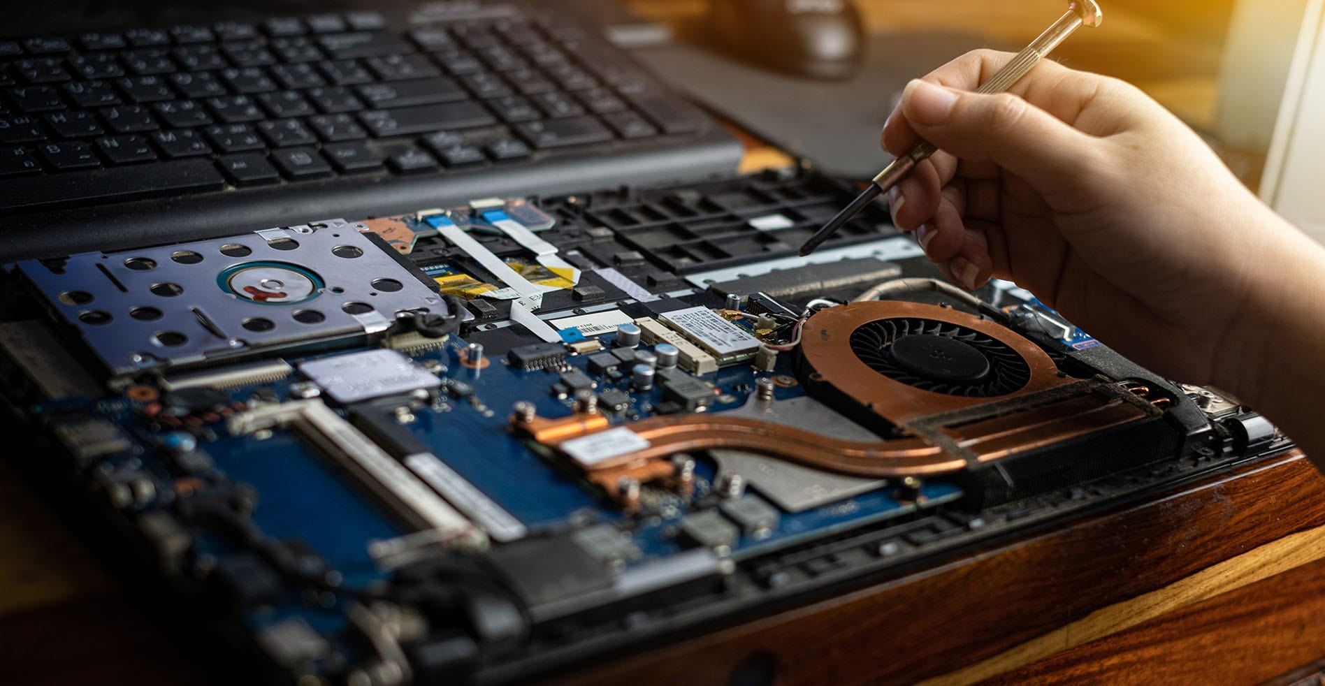 Person using tool to fix inside of computer