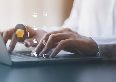 close up of person typing with files overlaid, concept of data loss prevention