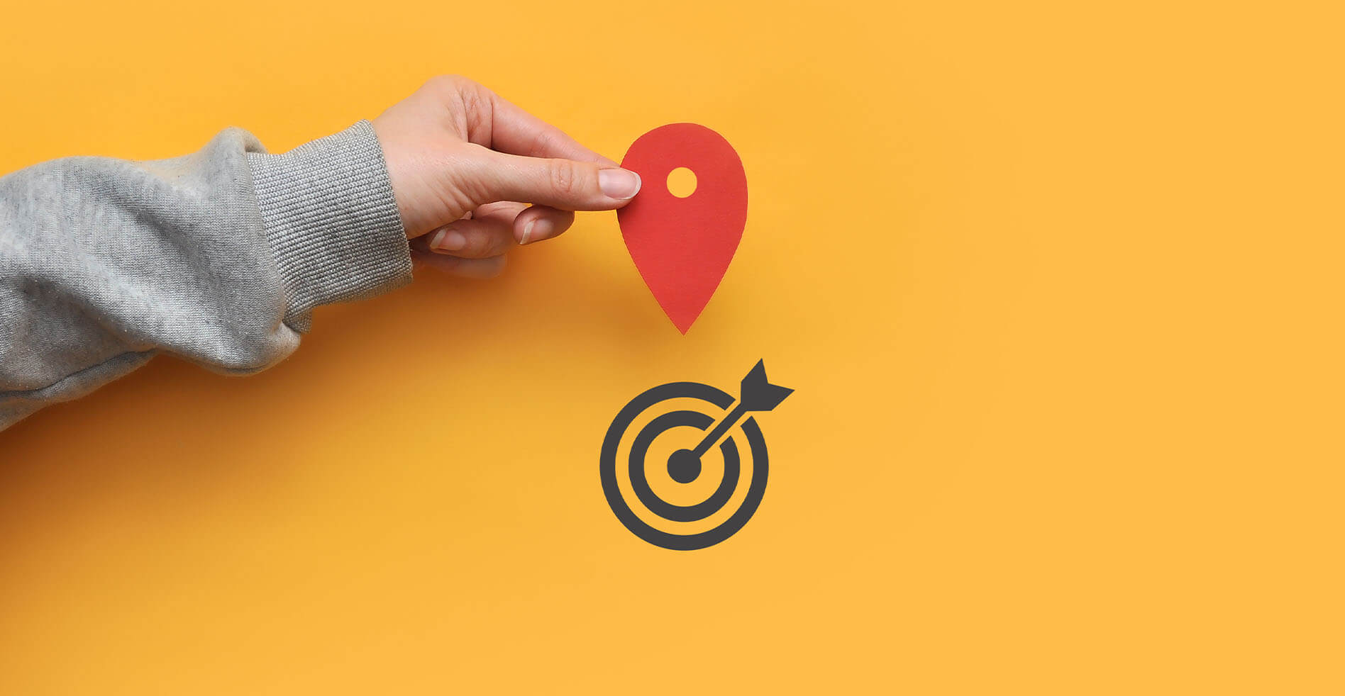hand holding a map pin over a bullseye to illustrate geofencing