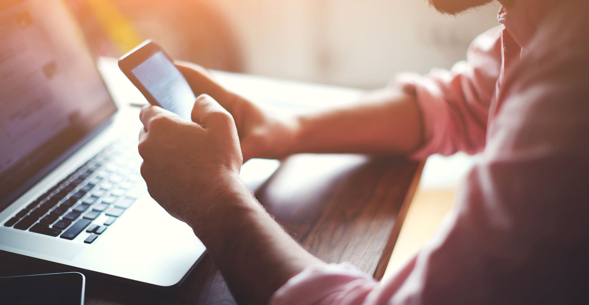 a person using a phone and laptop